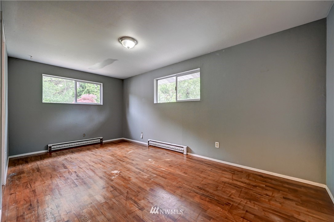 3232 Southeast 5th Street Renton, WA 98058 - Photo 11 of 20 an empty room with wooden floor and windows