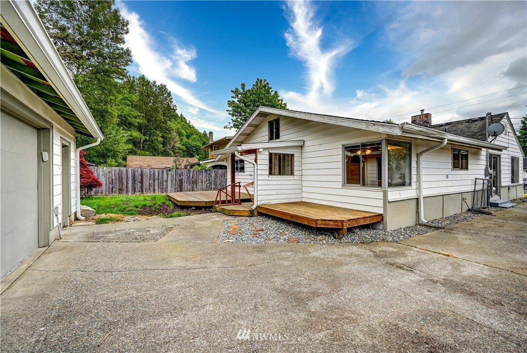 3232 Southeast 5th Street Renton, WA 98058 - Photo 19 of 20 a view of a white house with a small yard and large trees