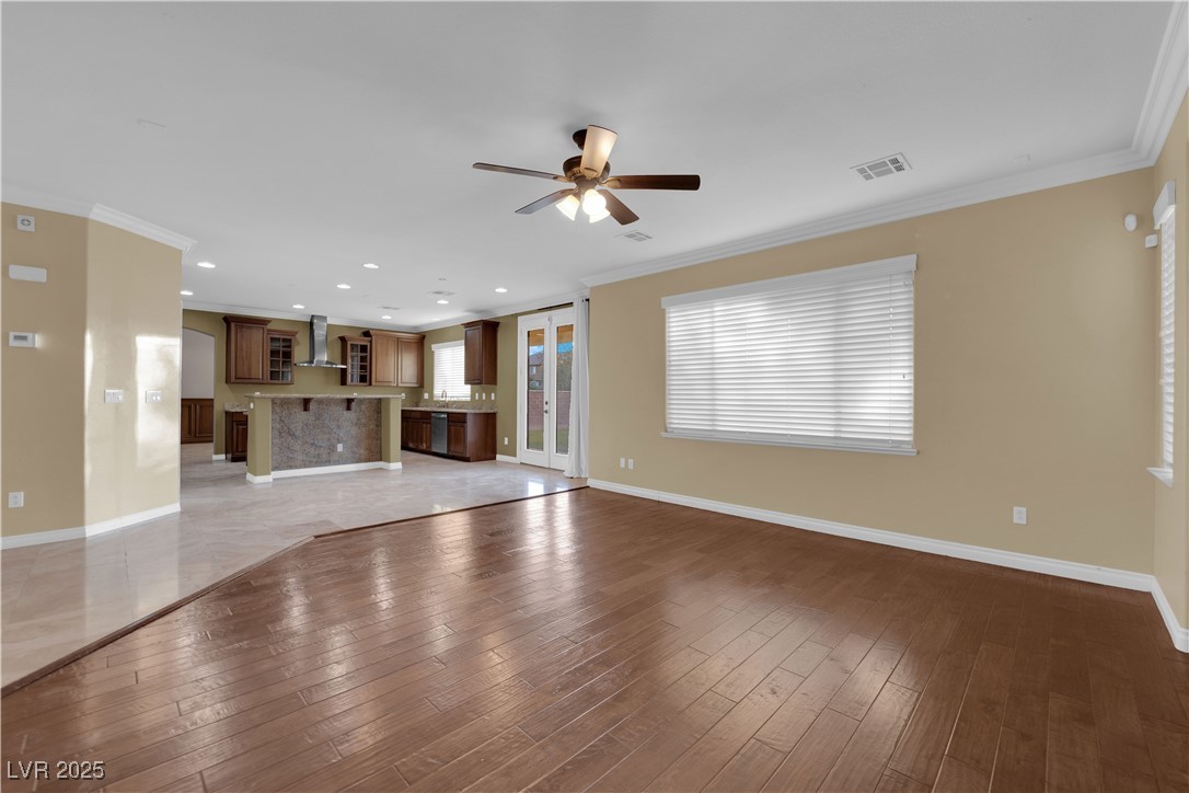 10057 Portula Valley Street Las Vegas, NV 89178 - Photo 20 of 56 Unfurnished living room with crown molding, light wood-style floors, ceiling fan, and recessed lighting