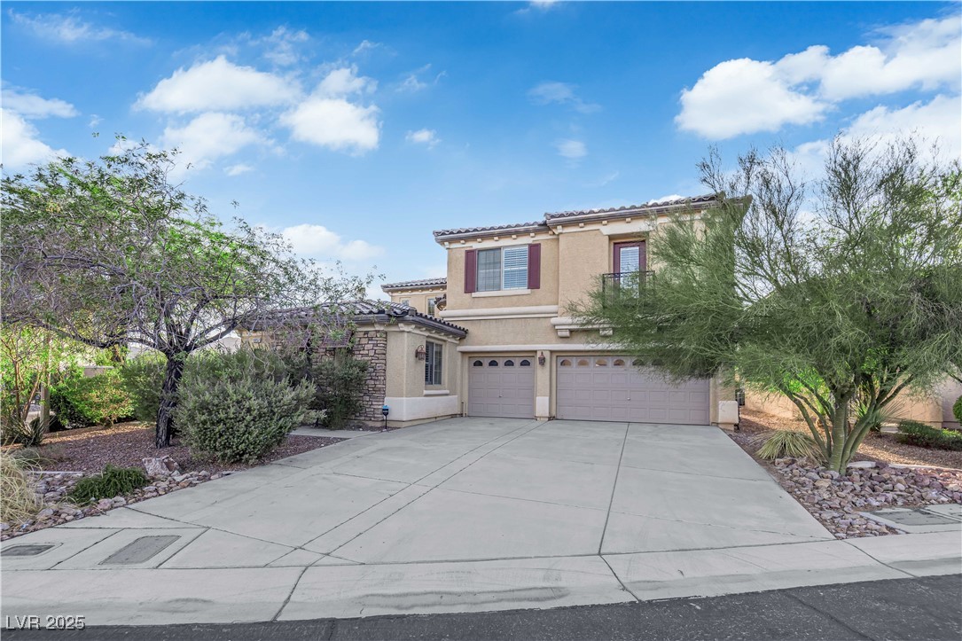 10057 Portula Valley Street Las Vegas, NV 89178 - Photo 2 of 56 Mediterranean / spanish home featuring stucco siding, a tiled roof, a garage, and concrete driveway