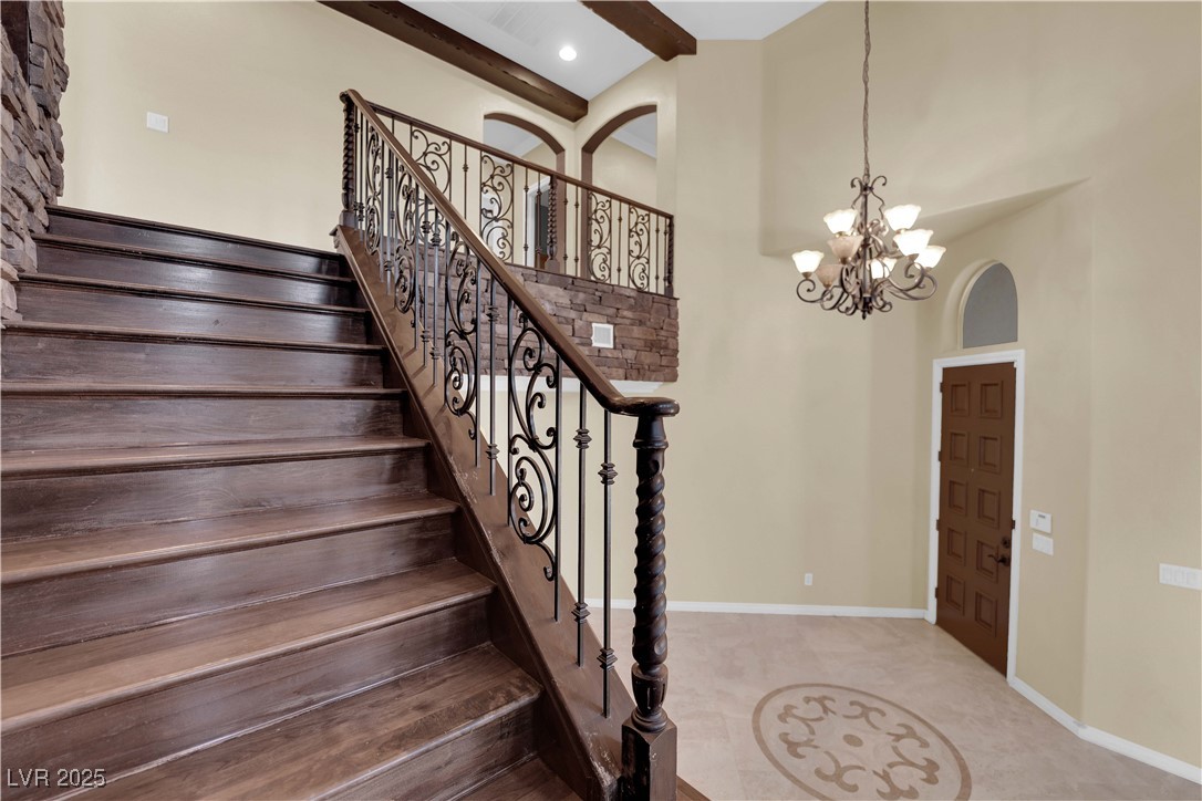 10057 Portula Valley Street Las Vegas, NV 89178 - Photo 26 of 56 Staircase featuring a chandelier, tile patterned floors, and a towering ceiling