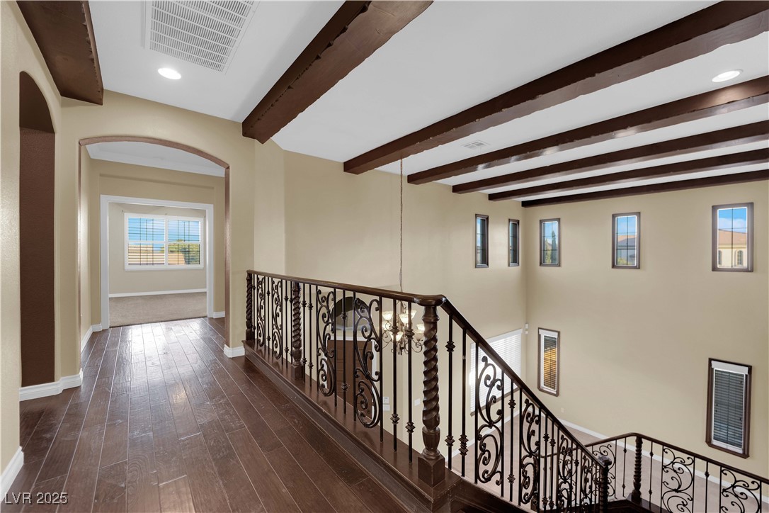 10057 Portula Valley Street Las Vegas, NV 89178 - Photo 27 of 56 Hall featuring arched walkways, beam ceiling, dark wood finished floors, recessed lighting, and an upstairs landing