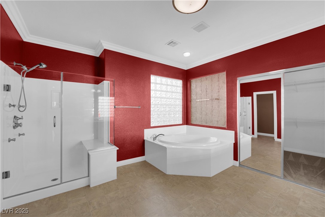 10057 Portula Valley Street Las Vegas, NV 89178 - Photo 34 of 56 Full bathroom with a shower stall, a garden tub, a spacious closet, and ornamental molding