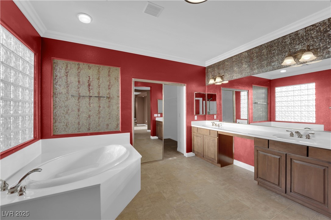 10057 Portula Valley Street Las Vegas, NV 89178 - Photo 35 of 56 Full bathroom with plenty of natural light, a bath, double vanity, and ornamental molding