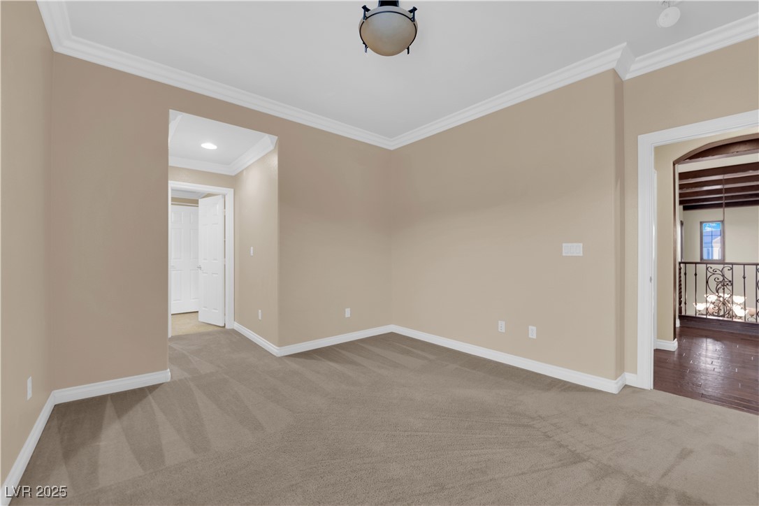 10057 Portula Valley Street Las Vegas, NV 89178 - Photo 42 of 56 Empty room featuring light colored carpet, ornamental molding, and beamed ceiling
