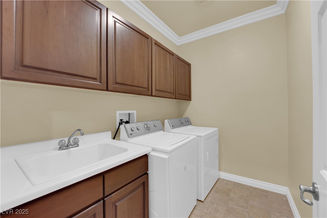 10057 Portula Valley Street Las Vegas, NV 89178 - Photo 44 of 56 Washroom with ornamental molding, cabinet space, washing machine and clothes dryer, and light tile patterned floors