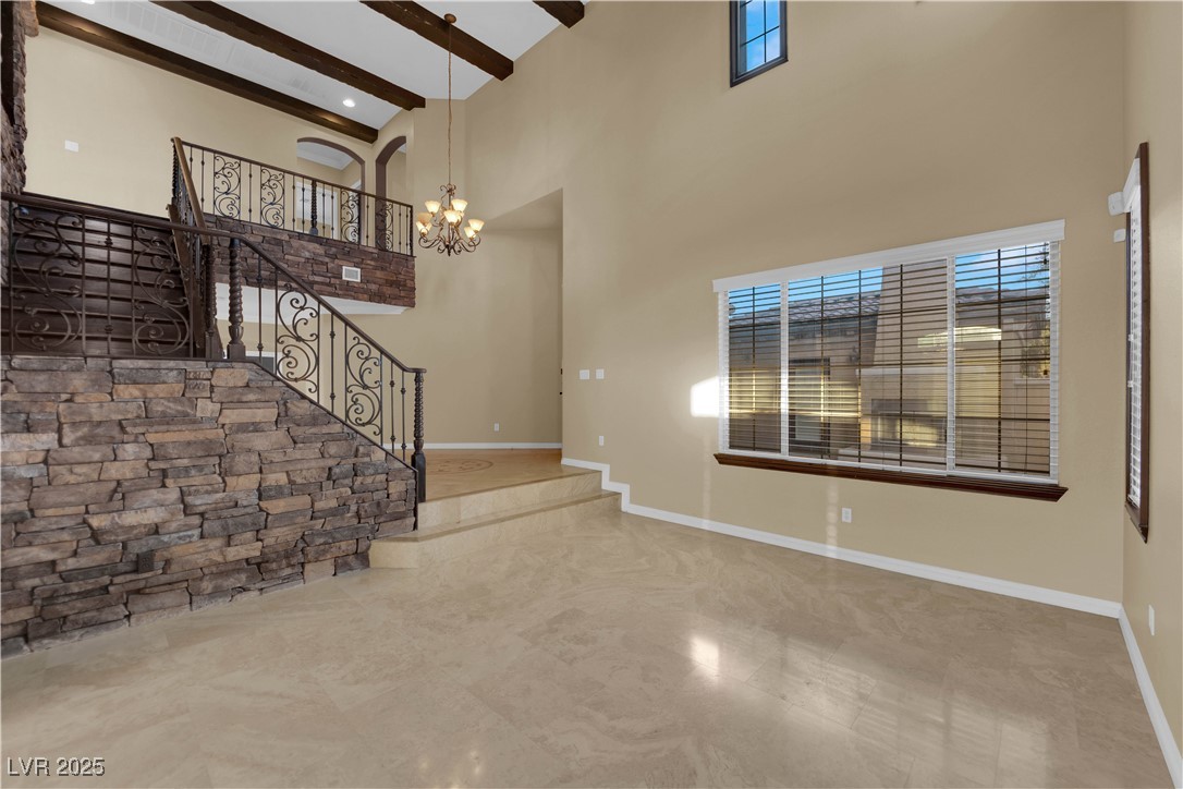 10057 Portula Valley Street Las Vegas, NV 89178 - Photo 6 of 56 Foyer with a high ceiling, beamed ceiling, stairs, and a chandelier