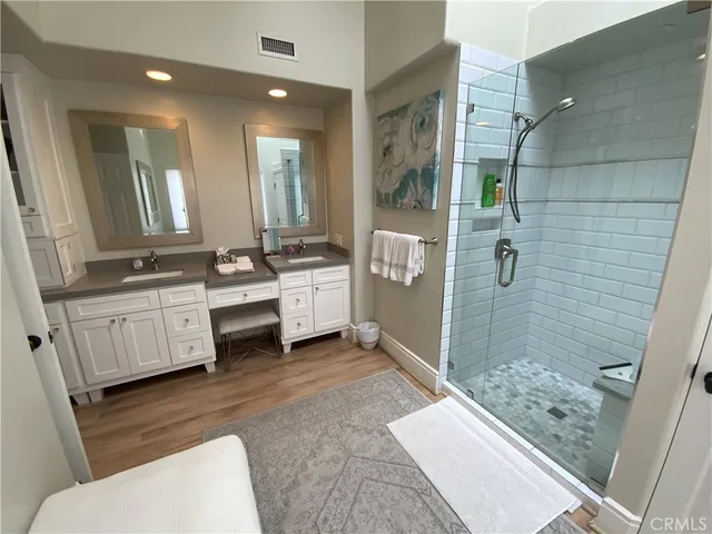 a bathroom with a double vanity sink toilet and shower