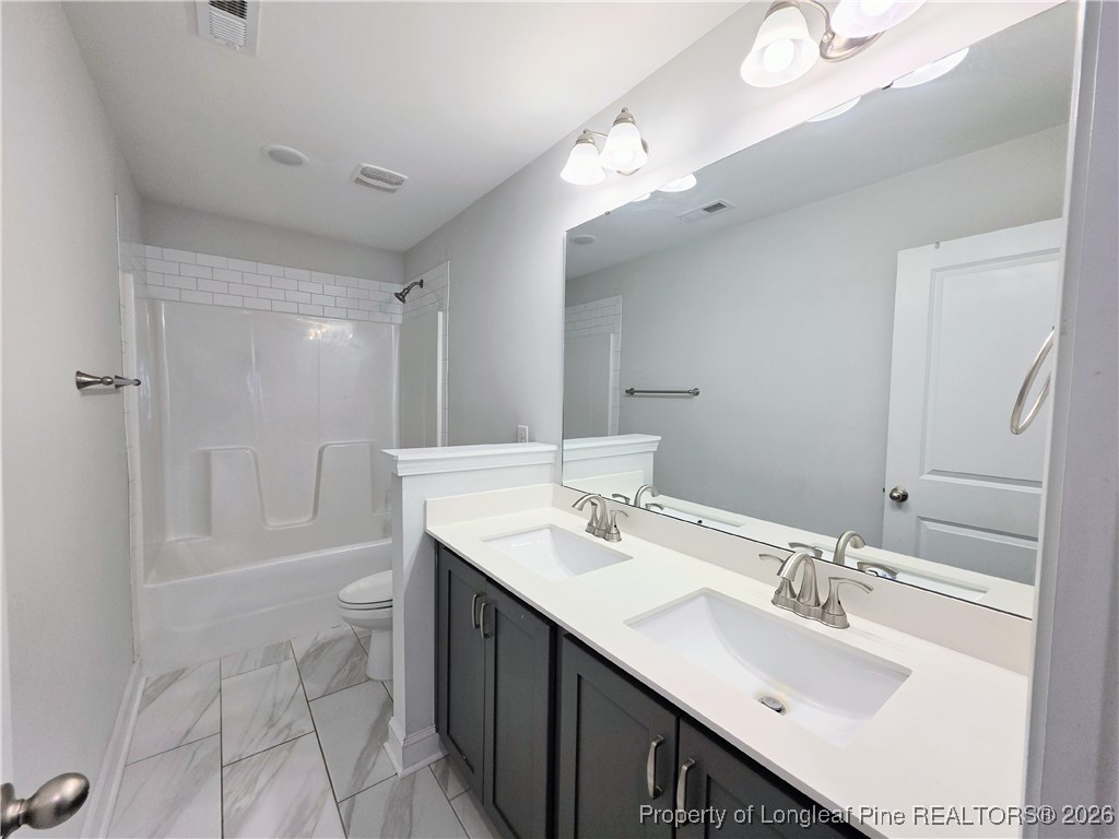 7850 Rufus Johnson Road Fayetteville, NC 28306 - Photo 18 of 25 a bathroom with a sink double vanity granite tub shower and a mirror