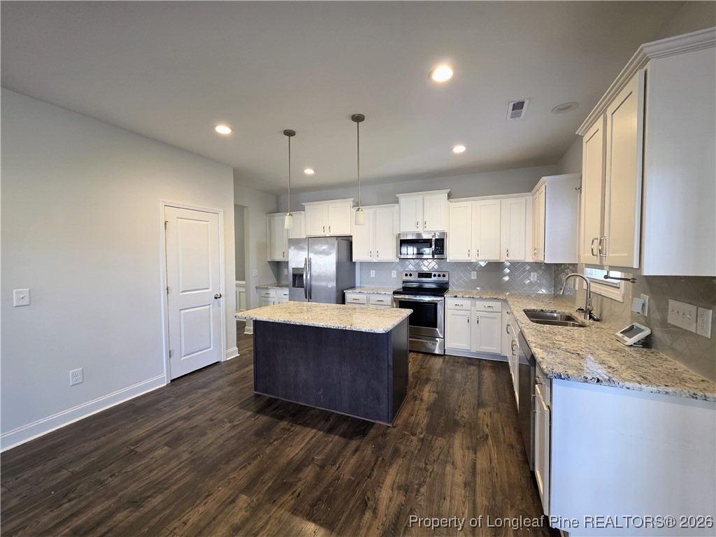 7850 Rufus Johnson Road Fayetteville, NC 28306 - Photo 6 of 25 a kitchen with granite countertop a sink cabinets and wooden floor