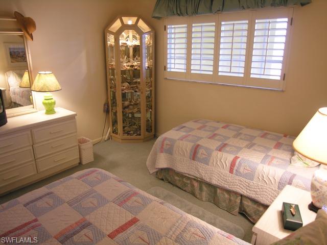 1051 3rd Street South, Unit 301 Naples, FL 34102 - Photo 11 of 15 a bedroom with a bed and a window