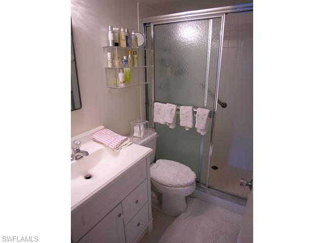 1051 3rd Street South, Unit 301 Naples, FL 34102 - Photo 15 of 15 a bathroom with a granite countertop sink toilet and shower