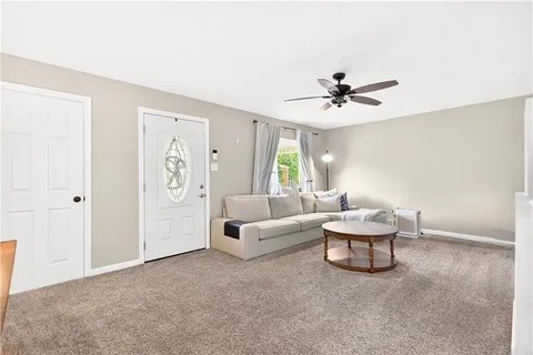 a living room with furniture and a ceiling fan
