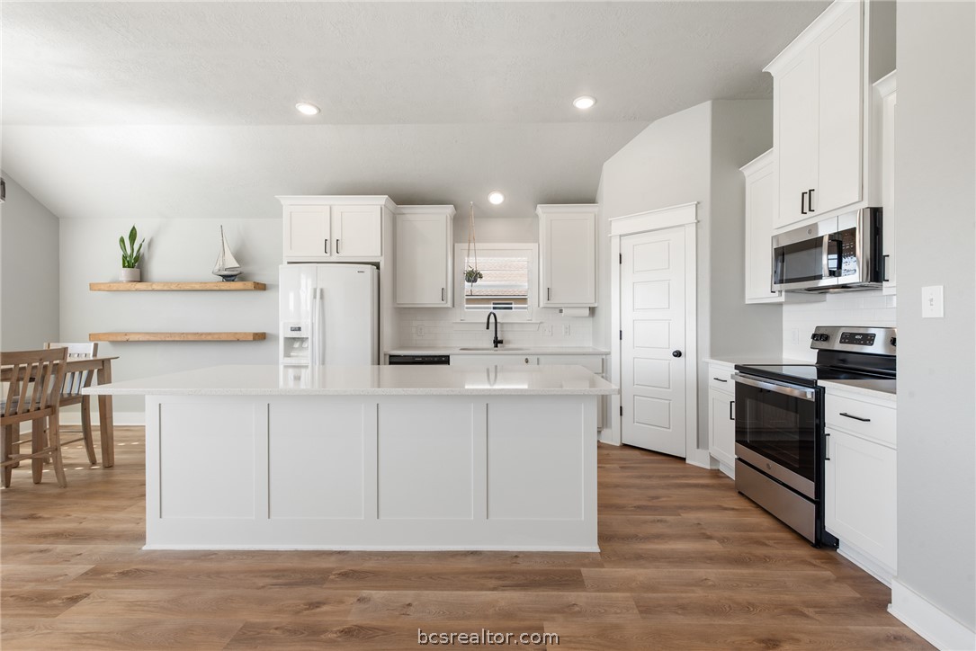 244 Brazos Bend Snook, TX 77879 - Photo 9 of 33 a kitchen with white cabinets and stainless steel appliances
