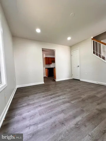 an empty room with wooden floor & closet area