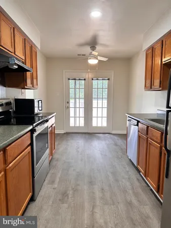 an empty room with chandelier fan and windows