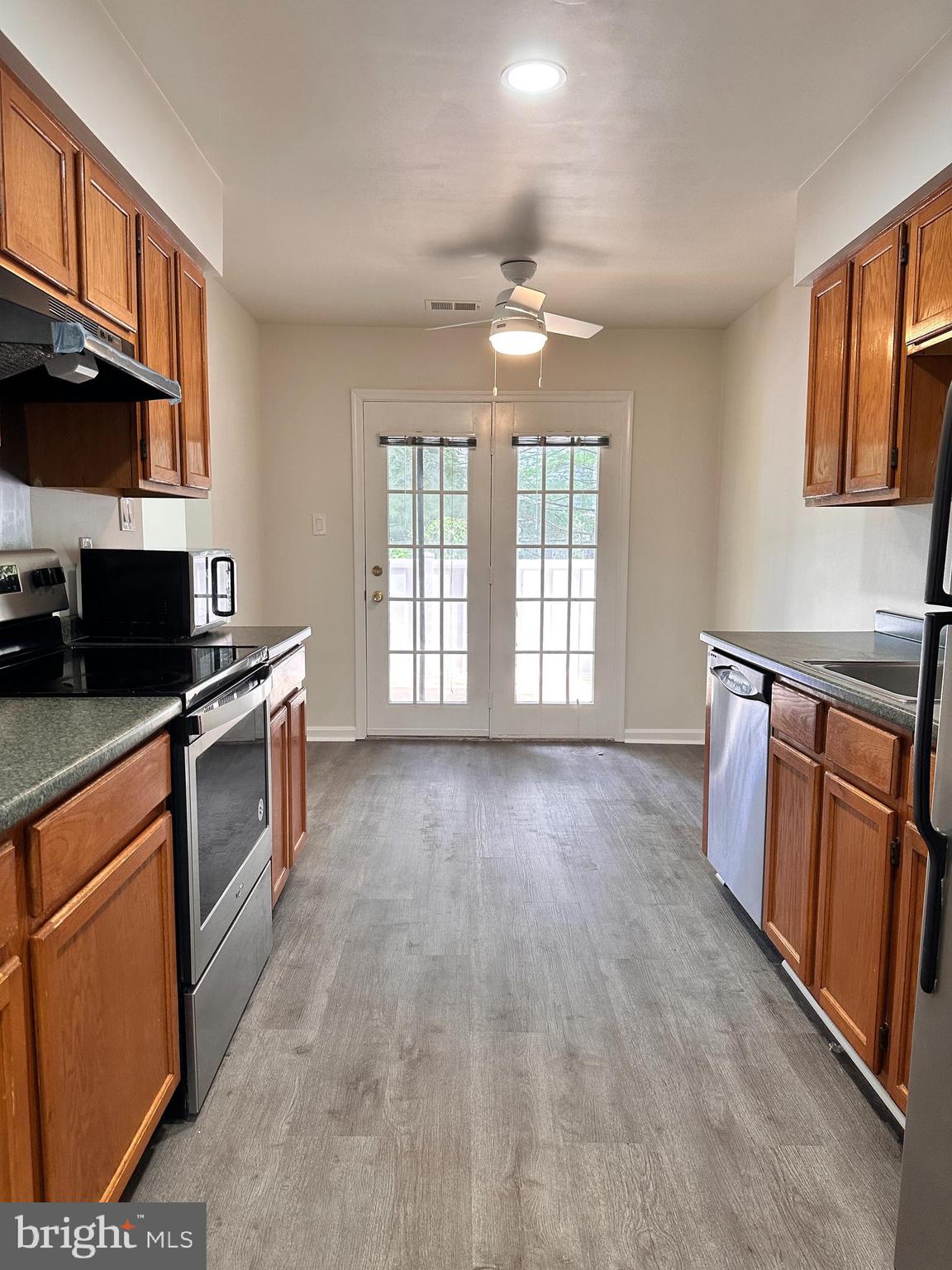 31 Amarillo Court, Unit 113 Germantown, MD 20874 - Photo 9 of 24 a kitchen with granite countertop a stove top oven a sink a window and cabinets