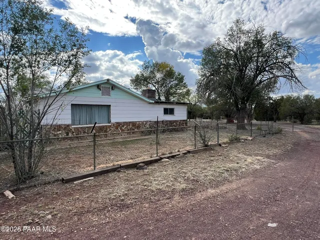 a view of a house with a yard and wooden fence