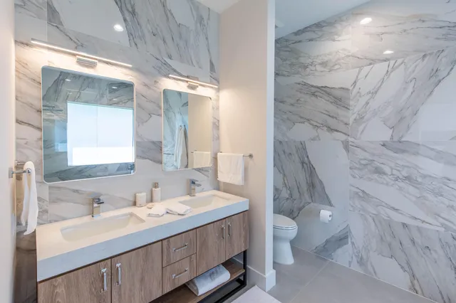 a bathroom with a double vanity sink toilet and shower