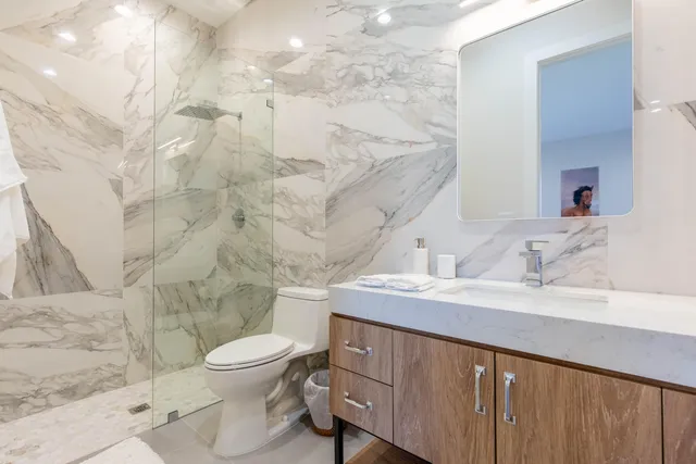 a bathroom with a sink a toilet and shower