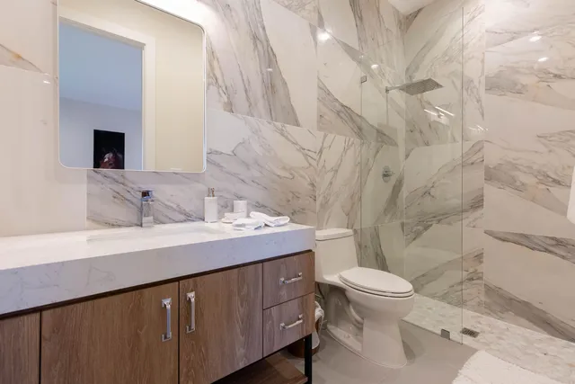 a bathroom with a sink a toilet and shower