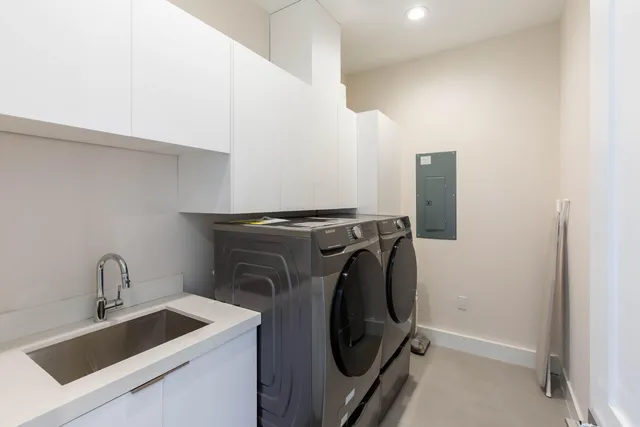 a utility room with sink dryer and washer