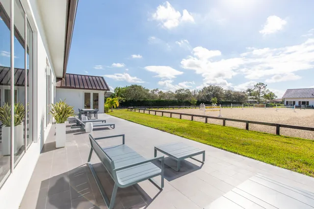 a view of swimming pool with a table and chair under an umbrella