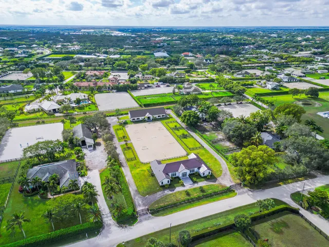 an aerial view of residential houses with outdoor space and parking