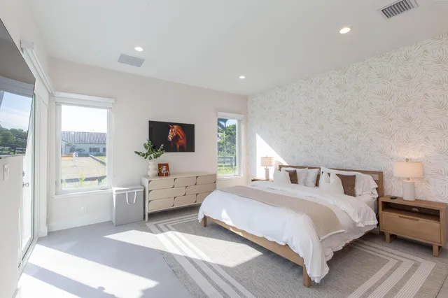 a spacious bedroom with a bed and large windows