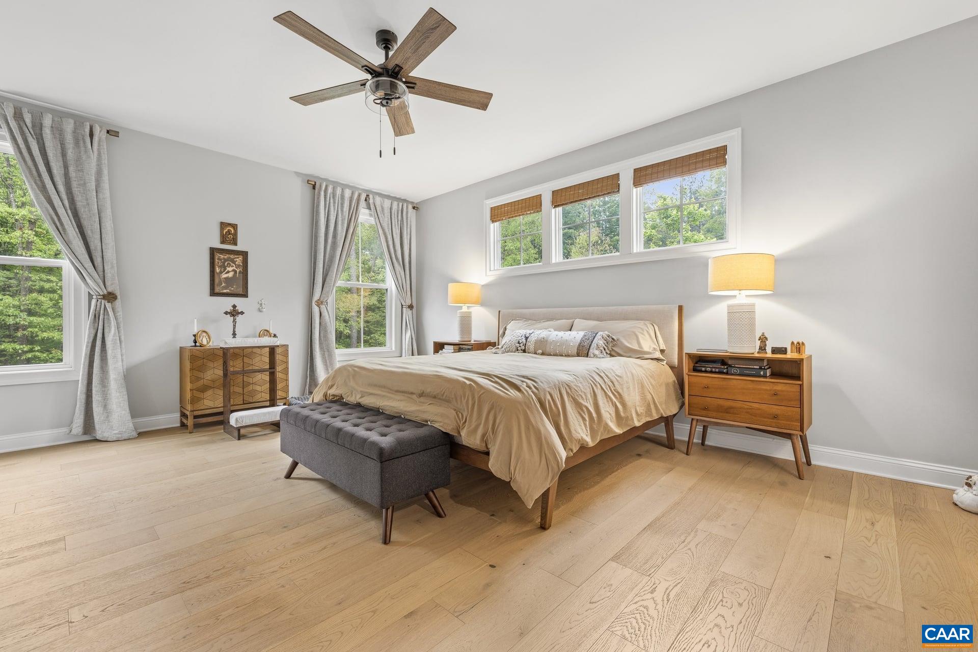 271 Two Rivers Drive Troy, VA 22974 - Photo 27 of 63 a spacious bedroom with a bed a couch and a window