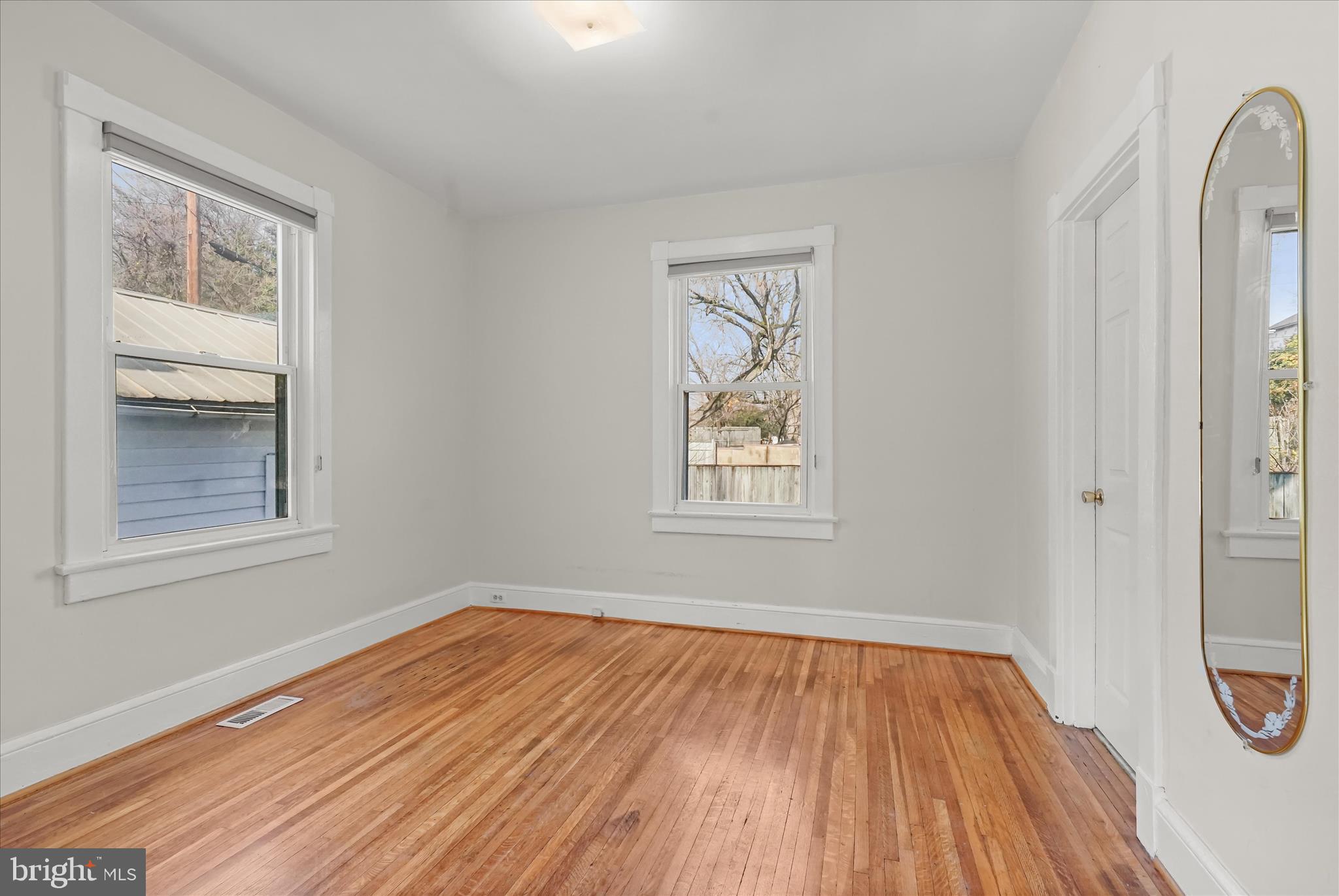1342 Hamlin Street Northeast Washington, DC 20017 - Photo 18 of 32 an empty room with wooden floor and windows