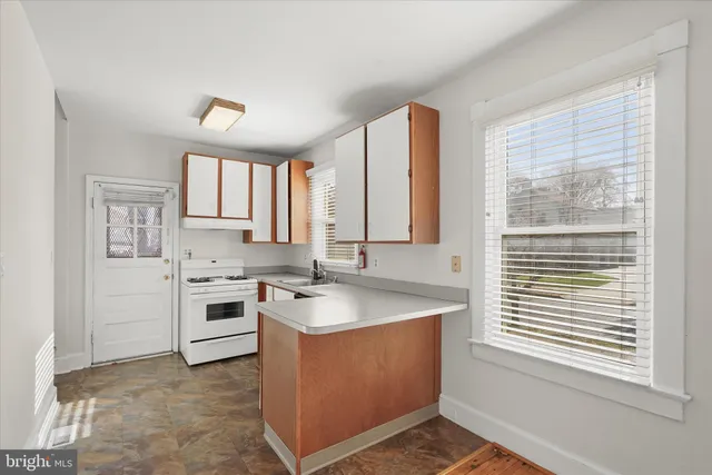 a kitchen with sink a stove and white cabinets