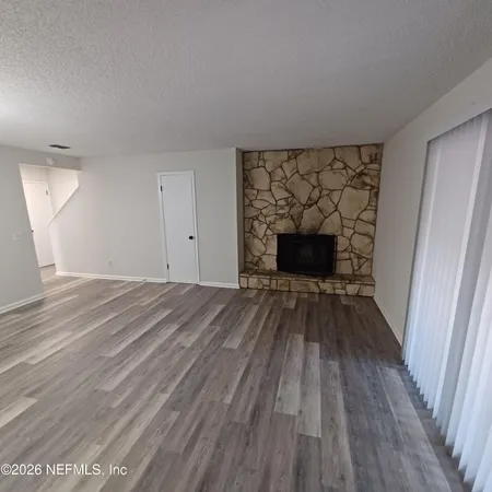 wooden floor fireplace and natural light in room