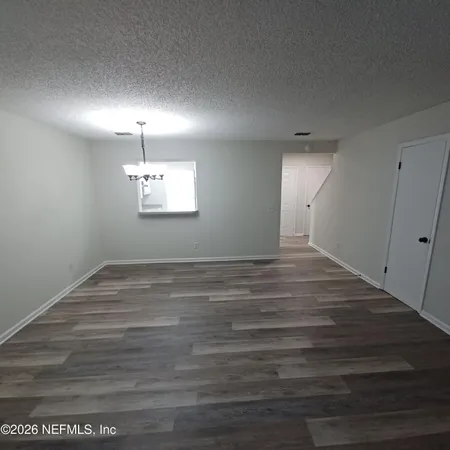 an empty room with wooden floor and window