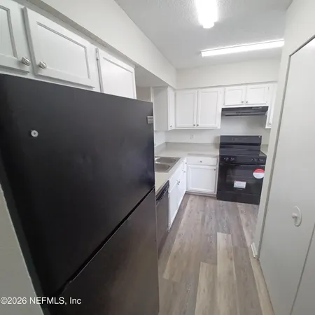 a kitchen with a refrigerator and a stove top oven