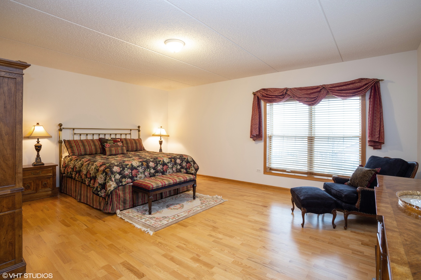 601 West Rand Road, Unit 202A Arlington Heights, IL 60004 - Photo 6 of 10 a bedroom with a bed and wooden floor