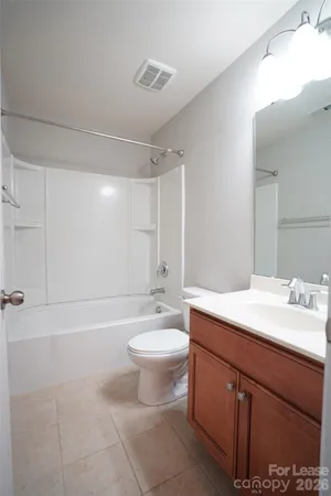 a bathroom with a sink a toilet a mirror and bathtub