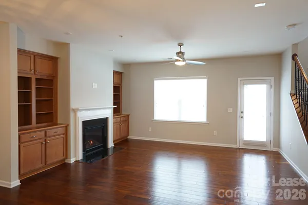 an empty room with windows fireplace and a sink