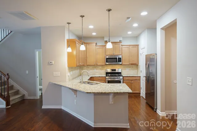 a kitchen with kitchen island a refrigerator a sink and a stove