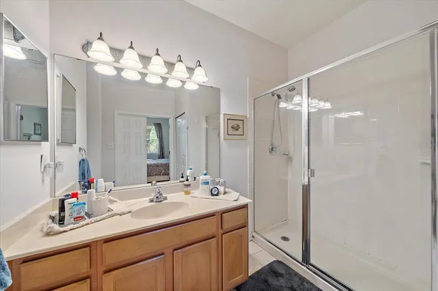 a bathroom with a double vanity sink mirror and shower