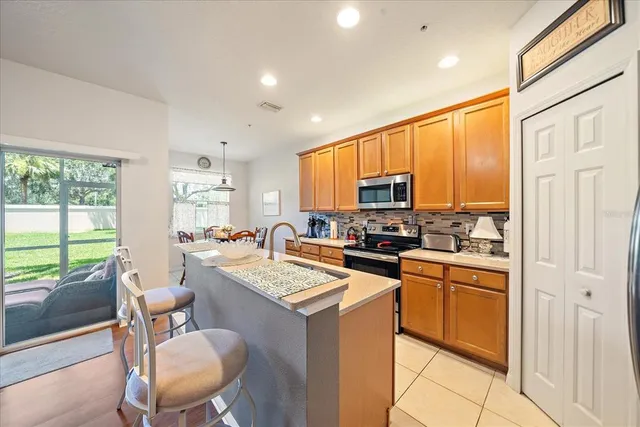 a kitchen that has a sink a table and chairs in it