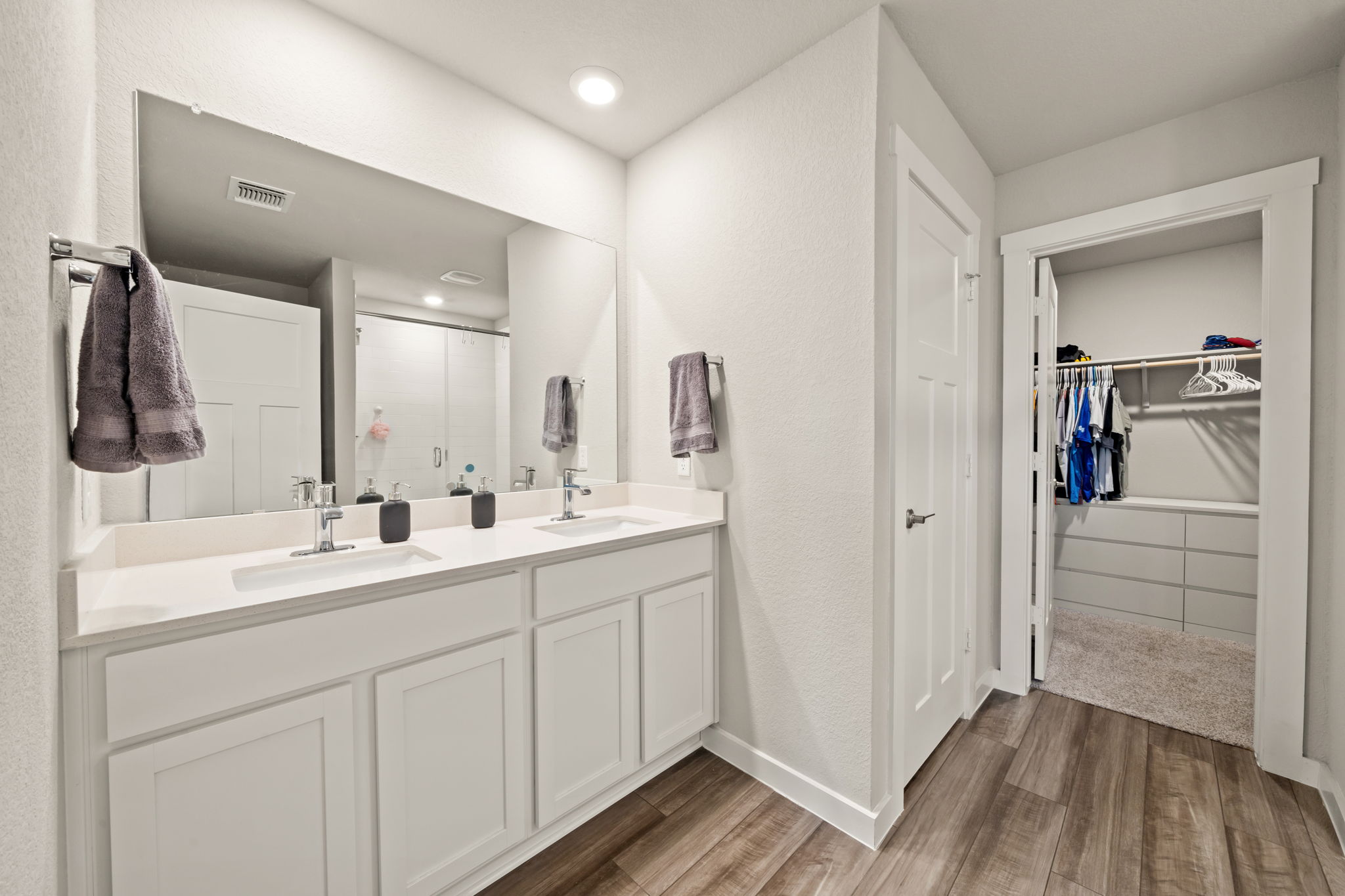 1117 Tipton Street Georgetown, TX 78633 - Photo 21 of 40 Bathroom vanity featuring dual sinks, white cabinetry, a large wall-mounted mirror, and recessed lighting
