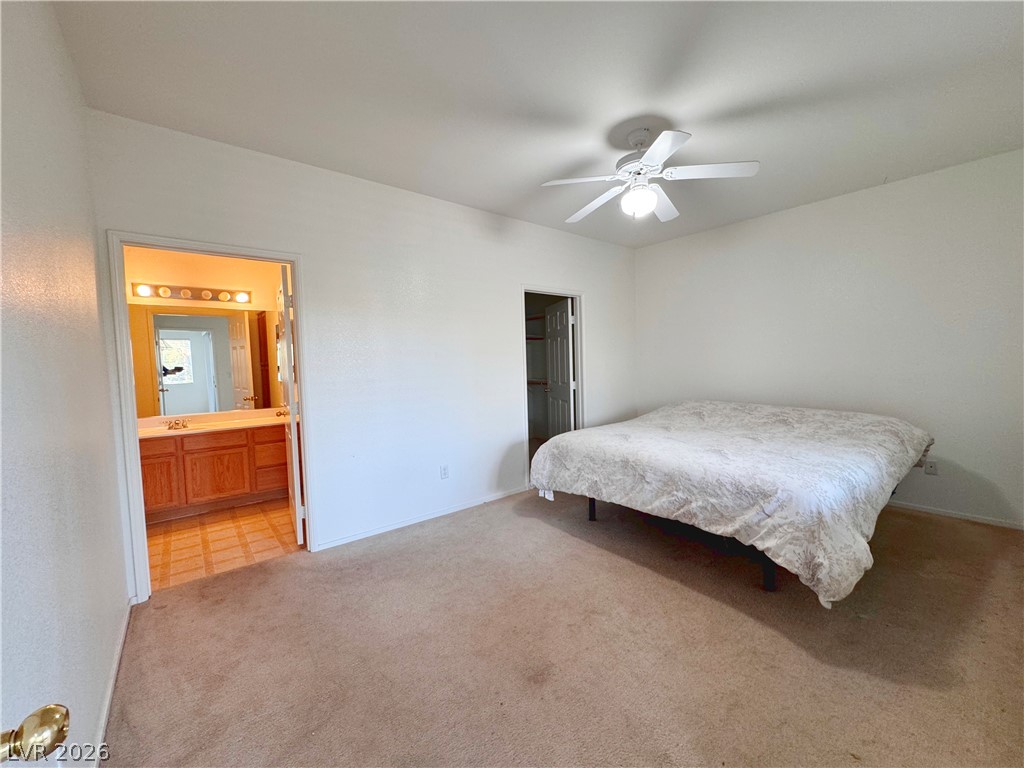 9580 West Reno Avenue, Unit 242 Las Vegas, NV 89148 - Photo 9 of 26 A comfortable bedroom with soft carpet, an adjoining bathroom, and a closet.