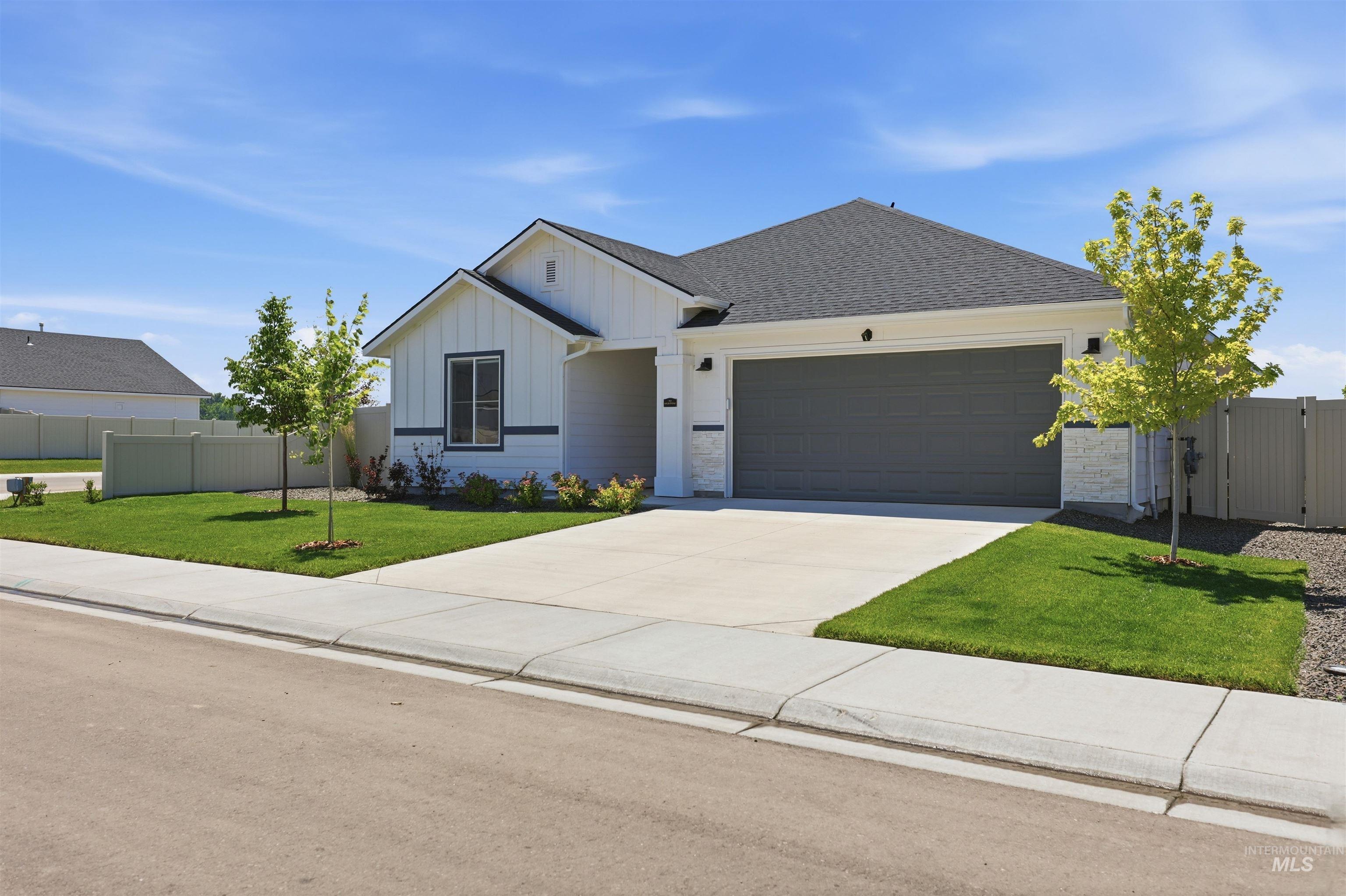 3811 West Maypearl Street Meridian, ID 83642 - Photo 3 of 39 Contemporary ranch-style residence featuring white vertical siding, a dark gray garage door, and a contrasting dark roof