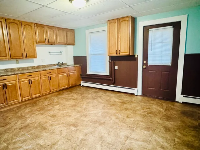 a kitchen with granite countertop a refrigerator and cabinets