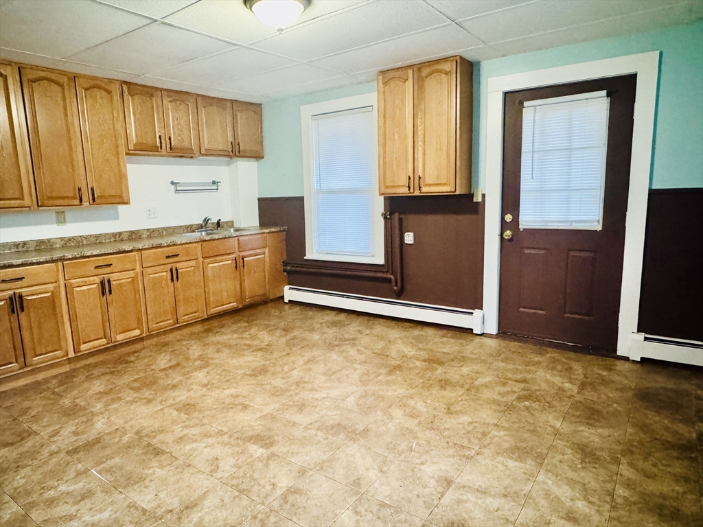 25 Cohasse Street, Unit 2 Southbridge, MA 01550 - Photo 1 of 8 a kitchen with granite countertop a refrigerator and cabinets