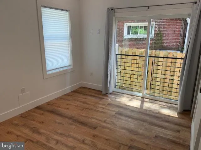 a view of a hallway with wooden floor and closet