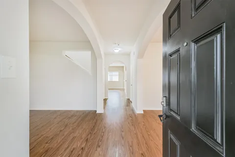 a kitchen with stainless steel appliances granite countertop a refrigerator a stove and a wooden floors