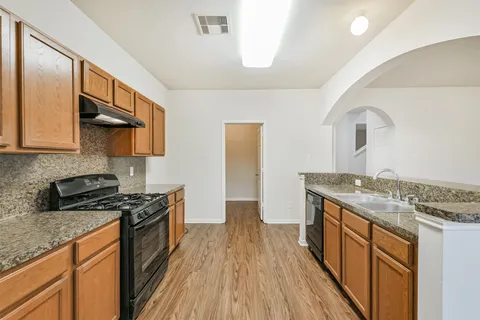a view of empty room with wooden floor and ceiling fan