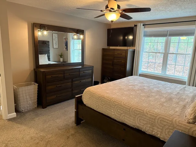 a bed sitting in a bedroom and chandelier fan